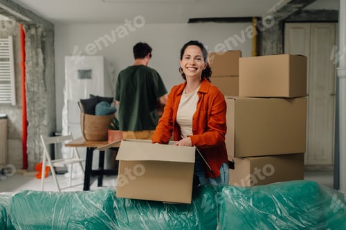 Preview: Couple unpacking cardboard boxes and moving into new home