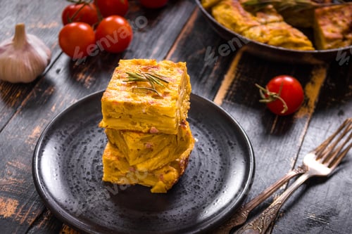 Preview: Slice of tortilla de patatas on a black plate