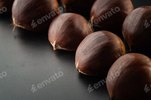 Preview: Rows of chestnuts isolated on black background