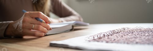 Preview: Wide view image of a woman writing in notebook