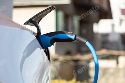Preview: EV electric car pluged charging at a recharge station in the city