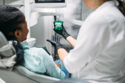 Preview: Dentist shows dentures to patient in dental clinic