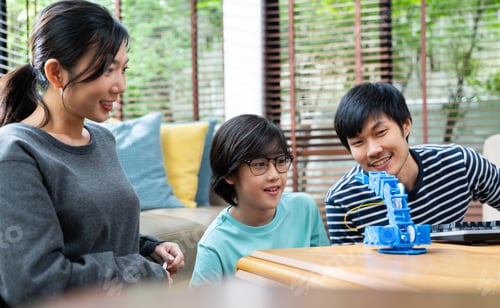 Preview: Asian kids program robotic cranes with laptops to learn about technology