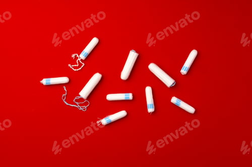 Preview: Pile of female tampons on red background