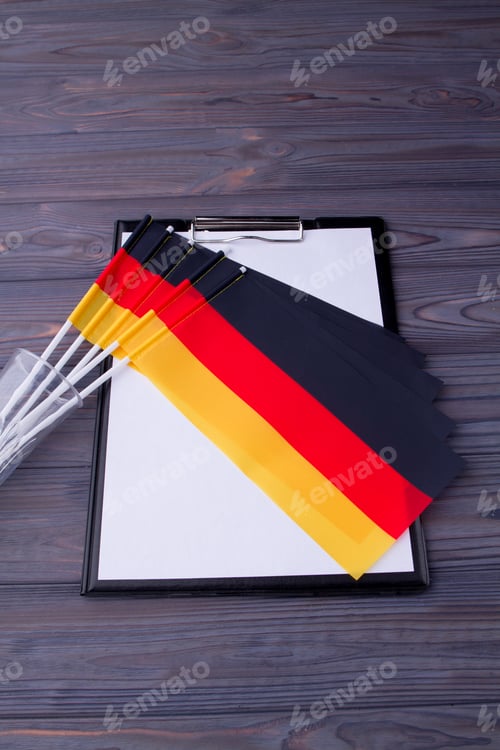 Preview: Vertical shot collection of Germany flags and clipboard with paper.