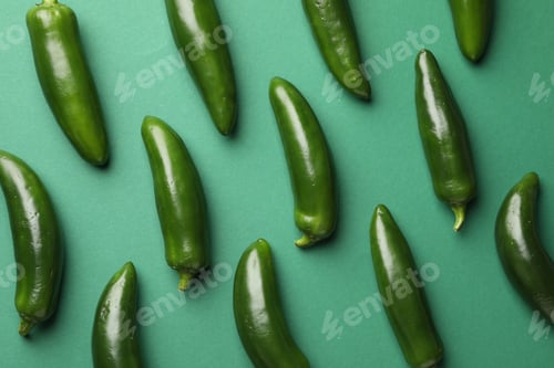 Preview: Ripe jalapeno peppers on green background, flat lay