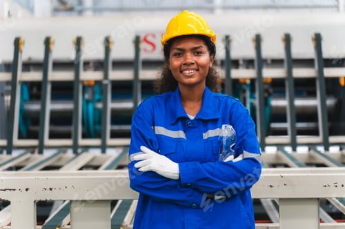 Preview: Portrait female professional engineer factory in protective uniform operating machine