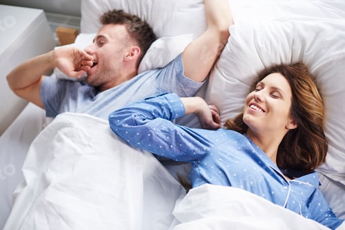 Preview: Couple stretching and yawning in bed