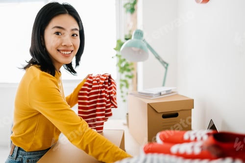 Preview: Female small business owner smiling at camera while working at showroom studio