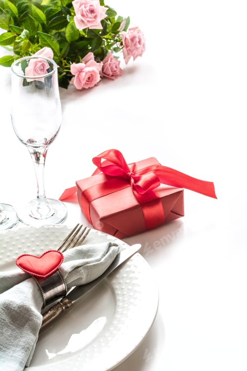 Preview: Valentines day dinner with table place setting with red gift, glass for champagne