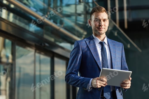 Preview: Businessman with digital tablet outdoors