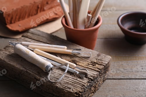 Preview: Set of different clay crafting tools on wooden table, closeup