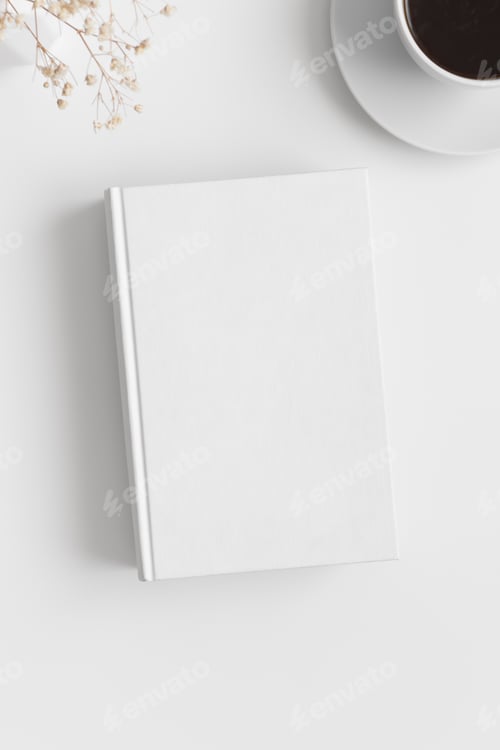 Preview: White book mockup with a cup of coffee and gypsophila on a white table.