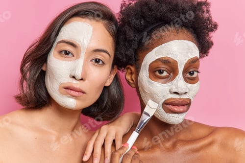 Preview: Serious women apply beauty masks on face do rejuvenation procedures at beauty salon pose with bare s