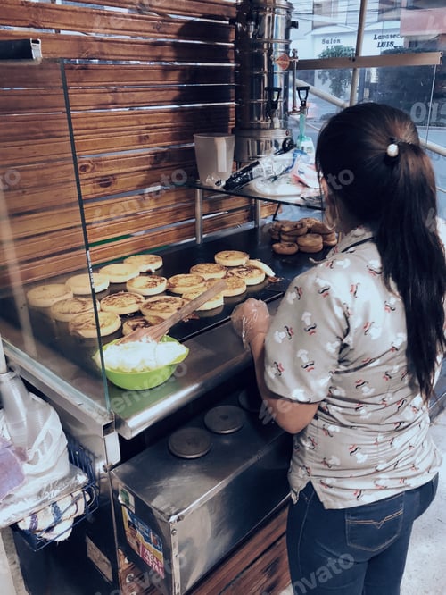 Preview: Young Hispanic Latino woman in her small “arepas” business in a tiny space next to a parking spot.