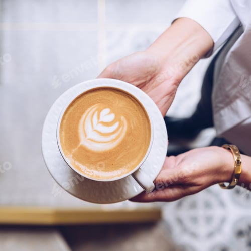 Preview: Woman is holding a cup of coffee, top view.
