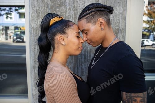 Preview: African American lesbian couple touching foreheads in tender moment together