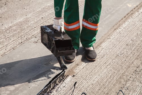 Preview: The man working asphalt pouring tar for road repair