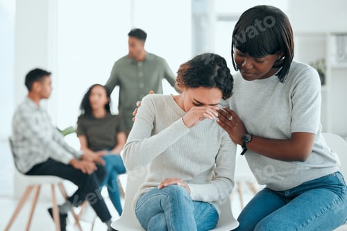 Preview: Shot of an attractive young woman sitting and comforting a member of her support group