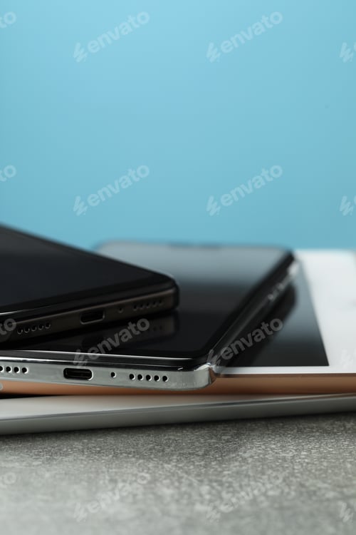 Preview: Stack of electronic devices on grey table, closeup