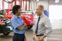 Preview: Male Pacific Islander auto repair shop manager talks to female Hispanic mechanic