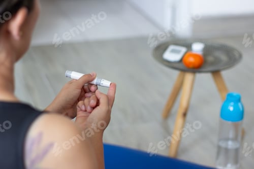 Preview: Woman Using Lancing Device to Check Blood Sugar