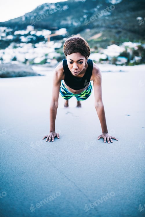 Preview: Young beautiful black women doing plank on the beach