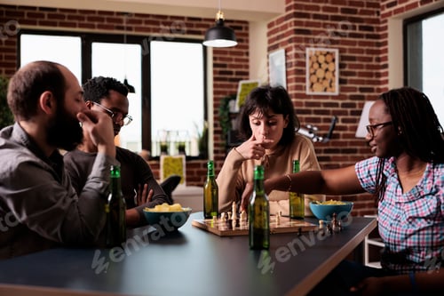 Preview: Smart multiethnic group of people sitting at table while playing chess.