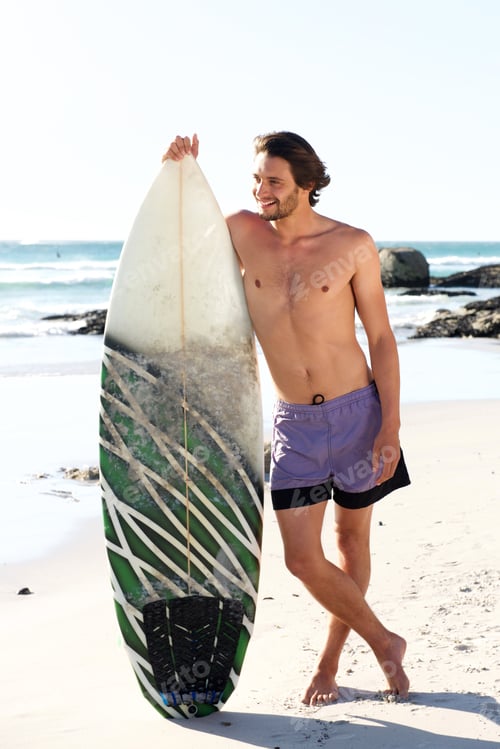 Preview: Handsome young surfer posing with his board