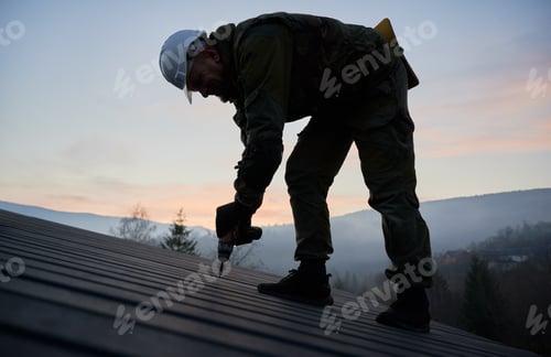 Preview: Builder installing corrugated iron sheet used as facade of future wooden frame house.