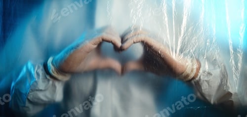 Preview: Doctor making heart symbol with covid suit