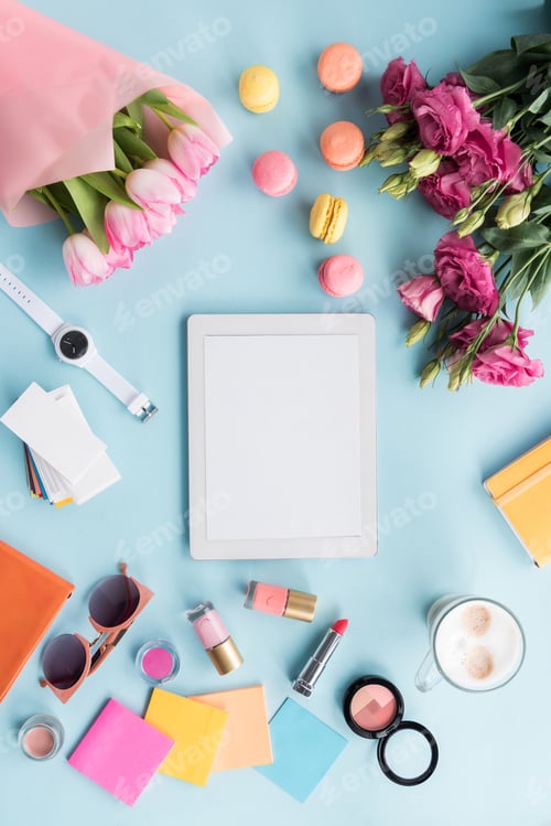 Preview: top view of tablet, various accessories, macarons and bouquets of flowers isolated on blue