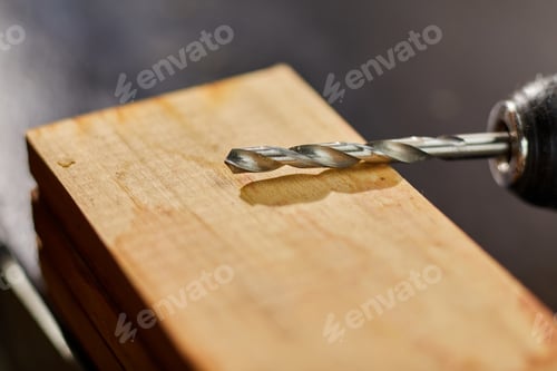 Preview: Close up of drilling into wood with screw twisted into place, metal drill bit