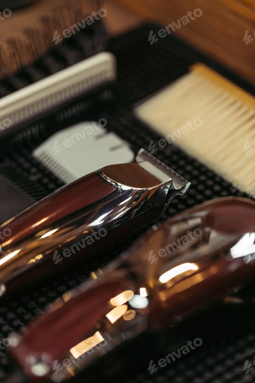 Preview: close-up view of electric clippers and various hair combs in barbershop