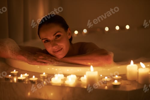 Preview: Cropped shot of a gorgeous woman relaxing in a candle lit bath