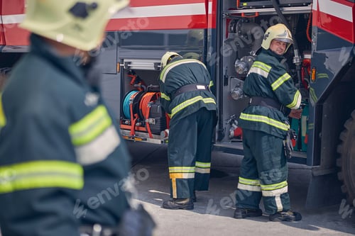 Preview: Man standing near the truck while looking at his colleague