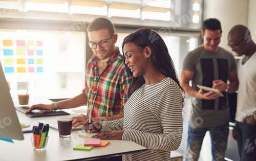 Preview: Cheerful young entrepreneurs working in the office