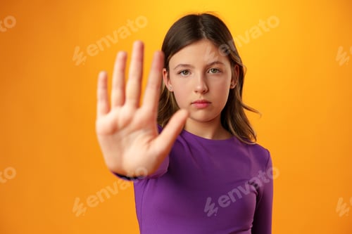 Preview: Teen girl extend hand in block gesture against yellow background