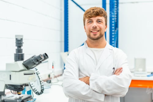 Preview: Young biologist standing with arms crossed in a laboratory