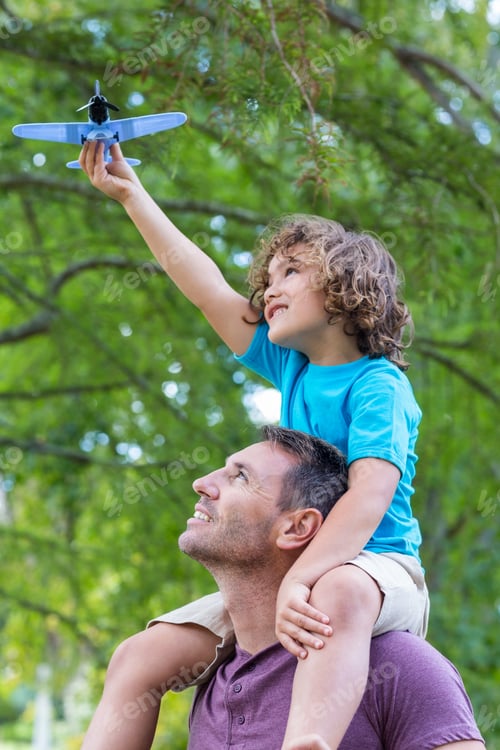 Preview: Father and son having fun in the park on a sunny day