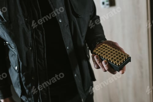 Preview: cropped image of man holding box with bullets