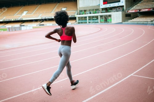 Preview: Female athlete running on track in stadium