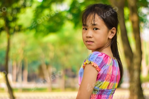 Preview: Close-up portrait of beautiful little girl in a summer green park.