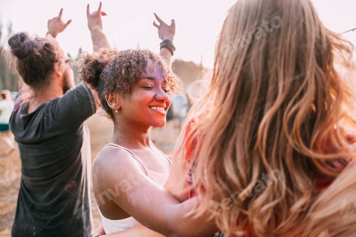 Visualização: Jovem afro-americana coberta de pó colorido com amigos no festival de holi