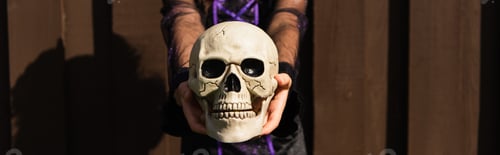 Preview: cropped view of girl holding spooky halloween skull outdoors, banner