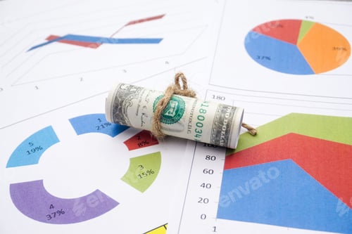 Preview: Flat lay of rolled dollar bills, and paper with charts - finances, economics concept