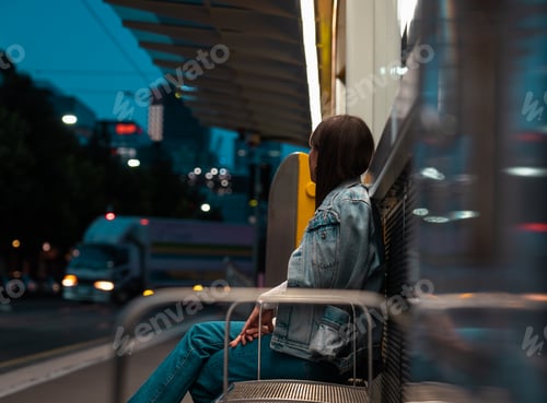Preview: a woman waiting in a bus for the train at night