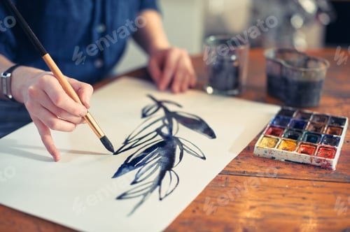 Preview: Young Woman Artist Working On Painting In Studio. Selective focus on foreground.