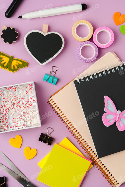 Preview: Crafting supplies for scrapbooking arranged on a purple surface