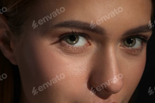Preview: Evil eye. Young woman with scary eyes on black background, closeup